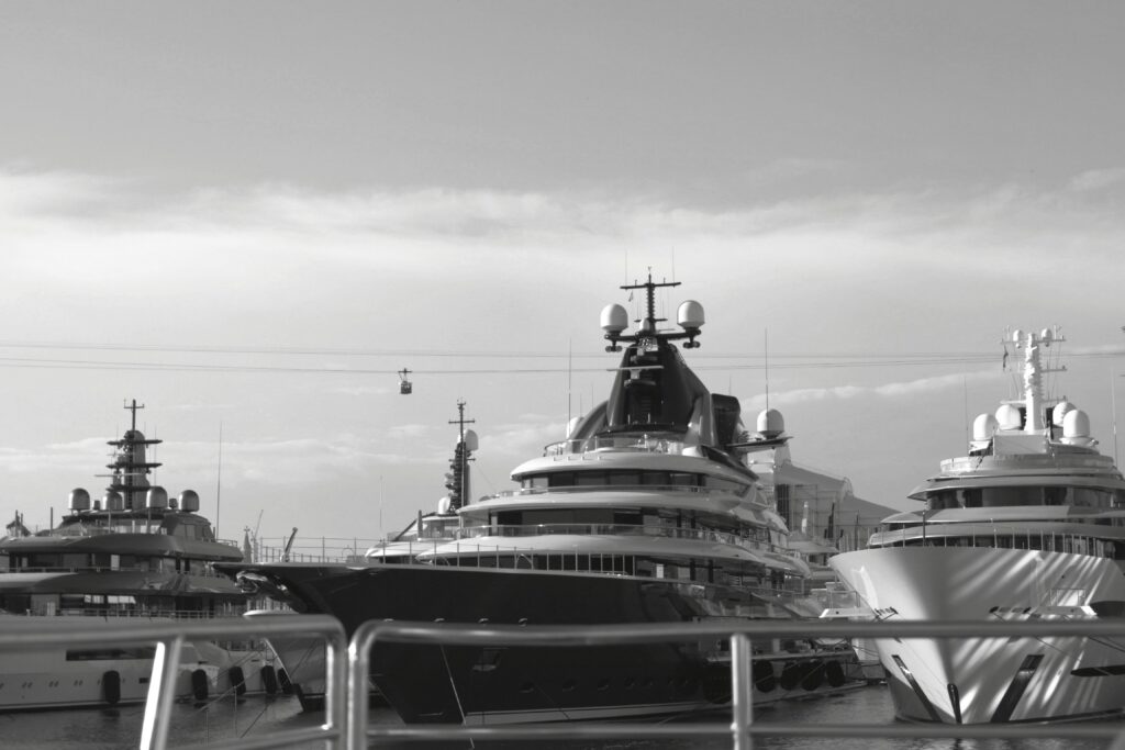 Black and white photo of luxury yachts docked at a harbor in Barcelona, Spain.